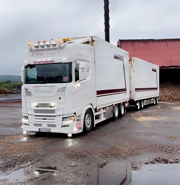 Volvo-lastebil parkert ved en rød bygning.